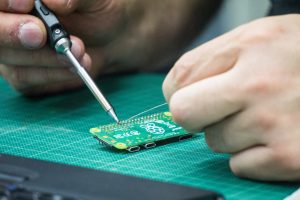 Ein Raspberry Pi wird mit einem Lötkolben bearbeitet